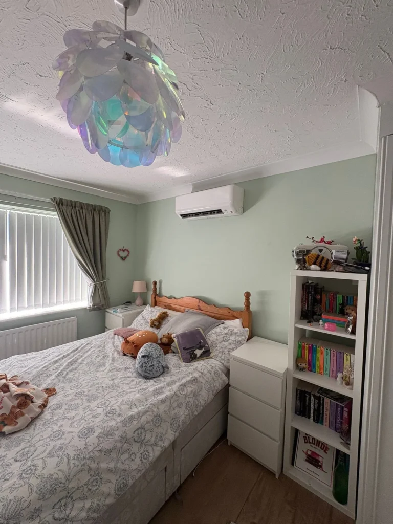 Wall-mounted air conditioning installed above the bed for comfortable bedroom cooling in Droitwich