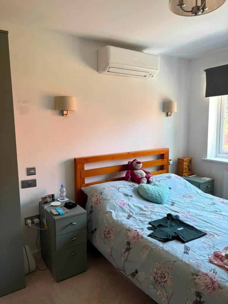 Mitsubishi wall-mounted air conditioning unit installed above the bed in a Dudley bedroom