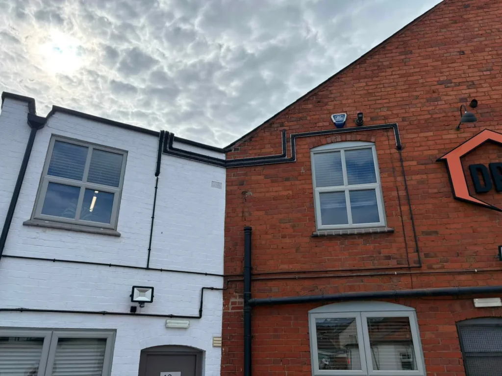 Discreet external air conditioning pipework routed across the Damp Proofing Solutions building in Lower Gornal