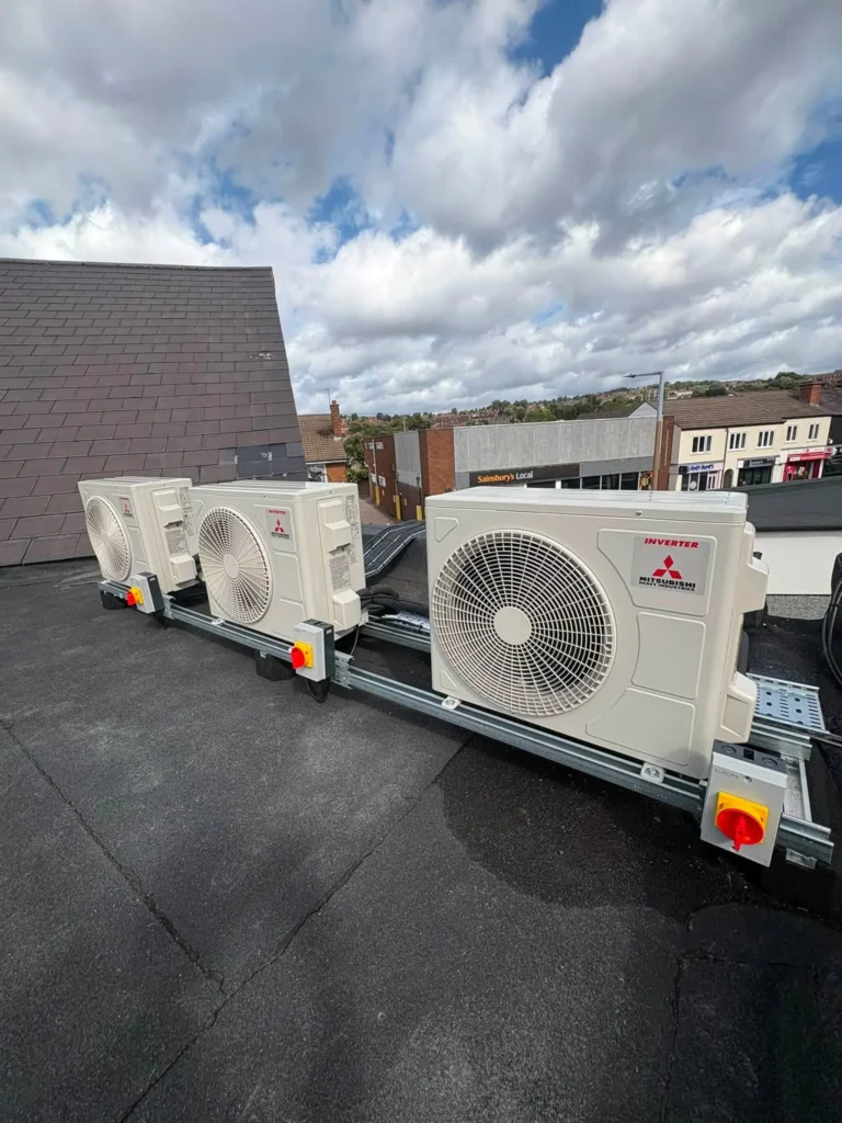 Three Mitsubishi air conditioning outdoor units mounted on the flat roof in Lower Gornal